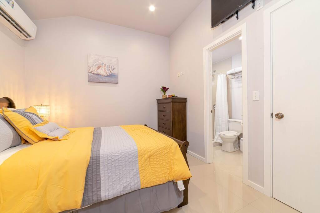 1 dormitorio con cama amarilla y baño en Yellow Bell (Mercy's Place) en Buckleys