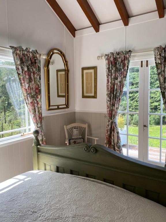 ein Schlafzimmer mit einem Bett und einem großen Fenster in der Unterkunft Cascade Cottage in Bombay