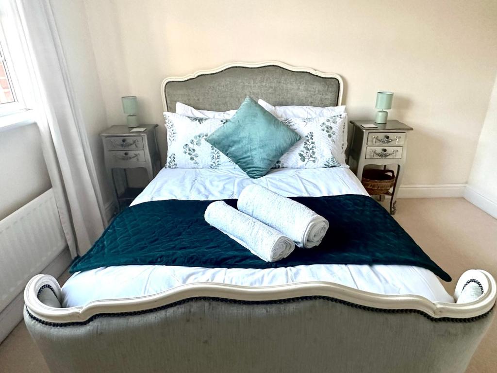 a bedroom with a bed with towels on it at 5 Bedroom Luxury House with Parking for 2 Cars in Desborough