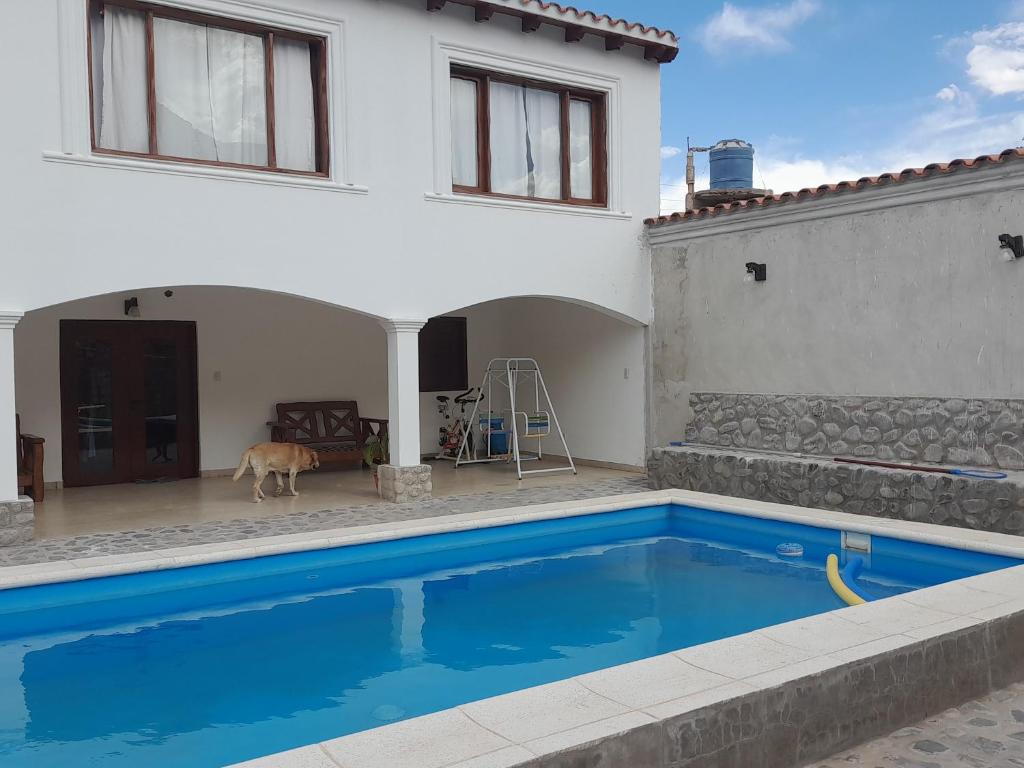 a villa with a swimming pool in front of a house at Hospedaje Lupé in Cachí