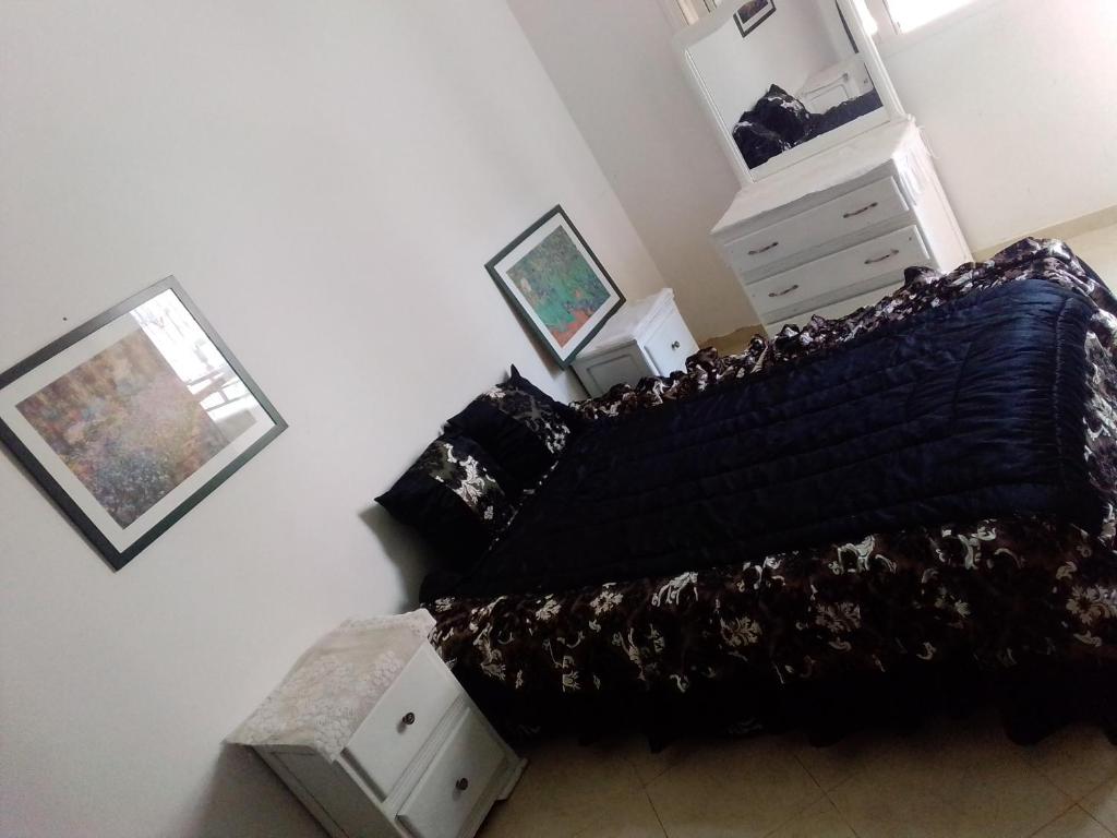 een slaapkamer met een bed met een zwart dekbed bij Azrou ifrane in Azrou