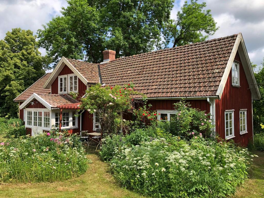 a red house with a garden in front of it at Övra Berg in Ullared