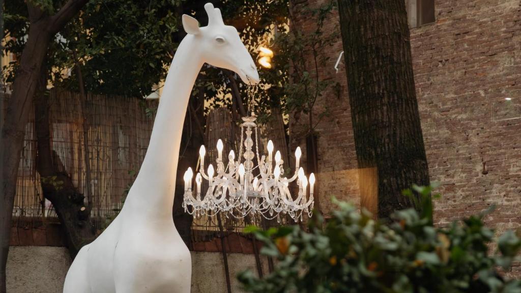 una statua di una giraffa accanto a un lampadario. di Hotel Indigo Florence, an IHG Hotel a Firenze