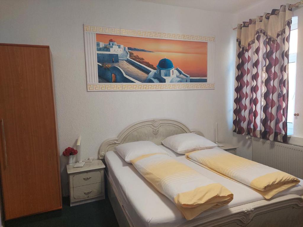 a bedroom with two beds and a painting on the wall at Hotel Restaurant Rhodos in Elsterwerda