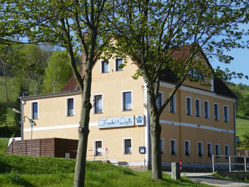 un bâtiment avec des arbres devant lui dans l'établissement „Frische Quelle“ Jonsdorf, à Jonsdorf