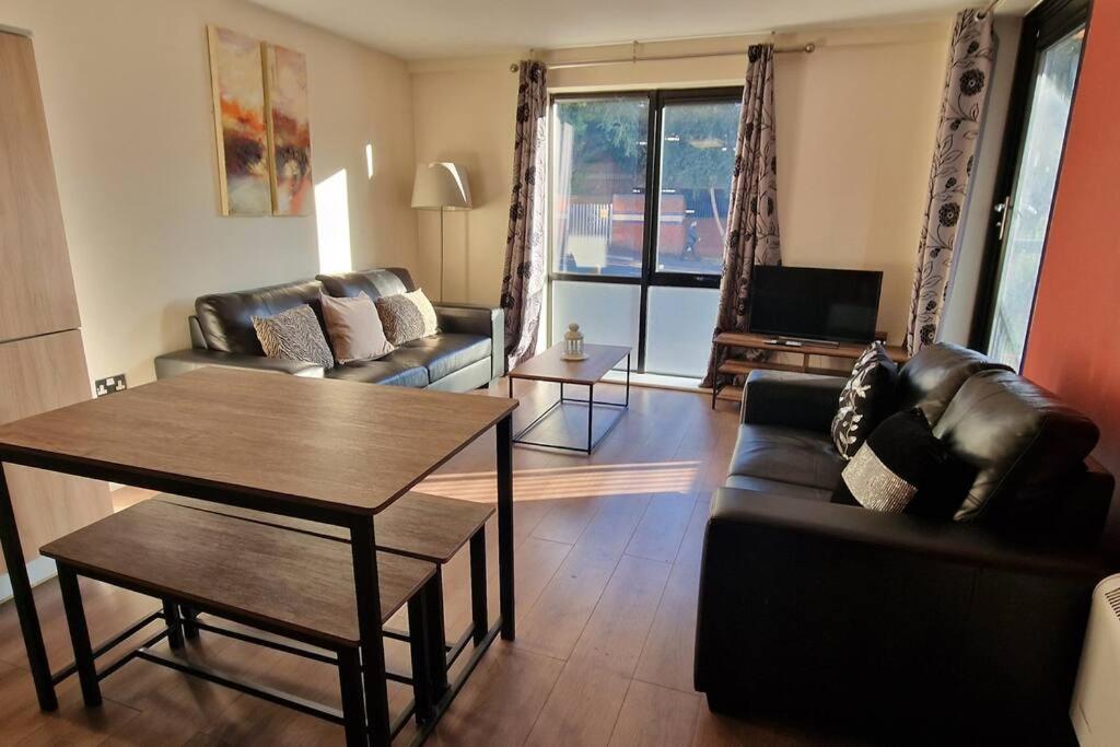 a living room with a couch and a table at 2 Bedroom Apartment Central Birmingham City Centre ( Parking ) in Birmingham