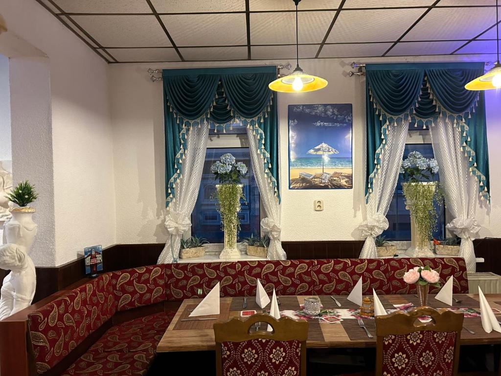 a restaurant with a red couch and two tables at Hotel Restaurant Rhodos in Elsterwerda