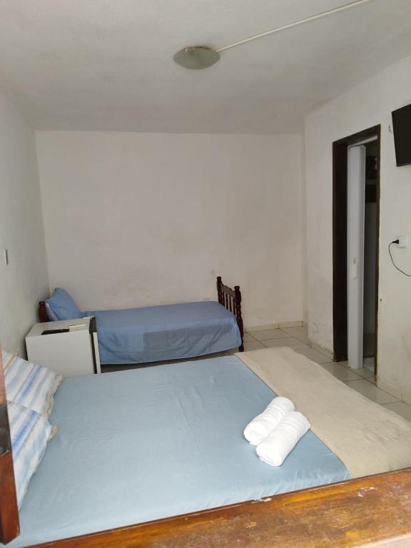 a room with two beds in a room with a tv at Pousada Encantos de Maceió in Maceió