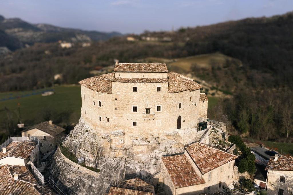 un ancien bâtiment au sommet d'une montagne dans l'établissement Castel Di Luco, à Acquasanta Terme