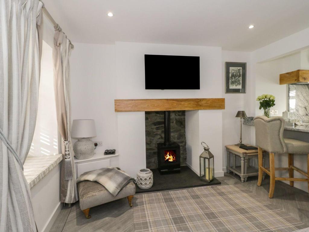 a living room with a fireplace and a tv on the wall at 9 Chapel Street in Conwy
