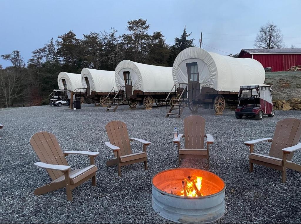 un grupo de cúpulas con sillas y una hoguera en Smoky Hollow Outdoor Resort Covered Wagon, en Sevierville