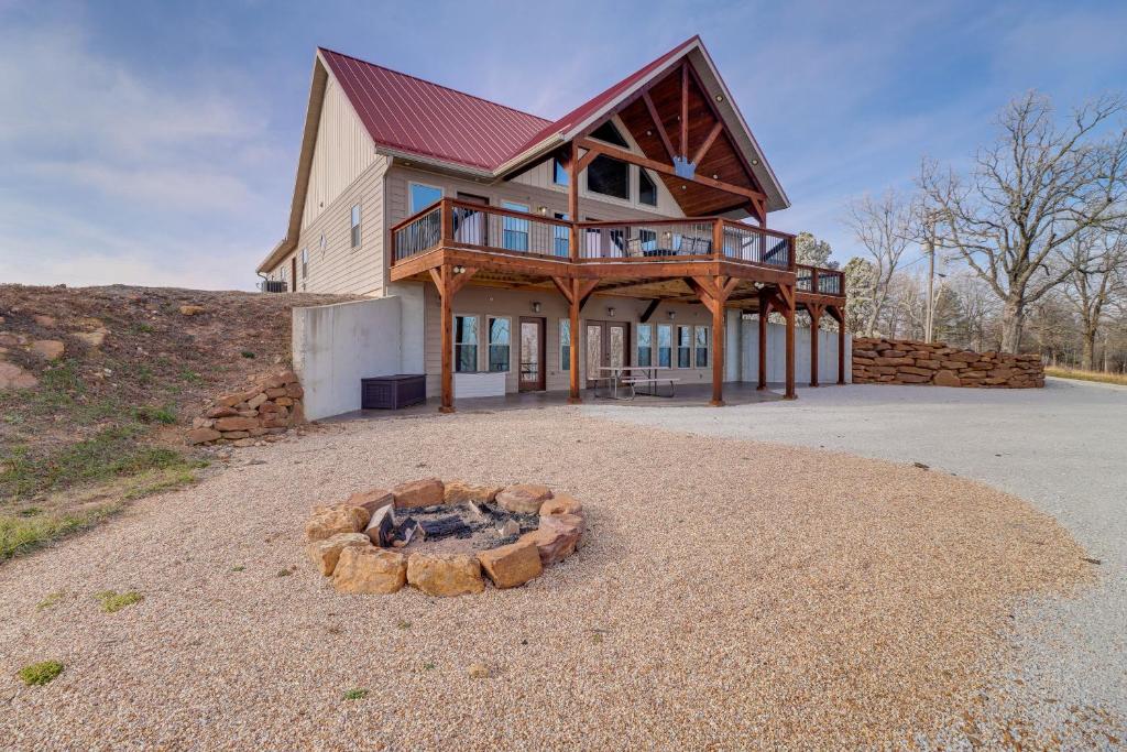 a house with a fire pit in front of it at Spacious Harrison Vacation Rental with Deck and Views! in Harrison