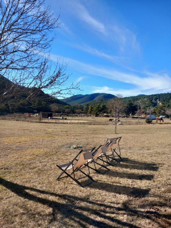 Peyroules的住宿－GÎTE LA MOUNTAGNA，坐在田野里的一排长椅