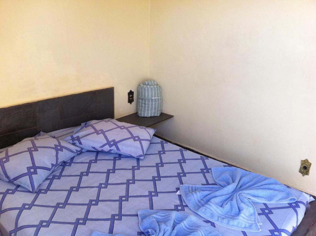 a bedroom with a bed with blue comforter at Cacique Hotel in Ribeirão Preto