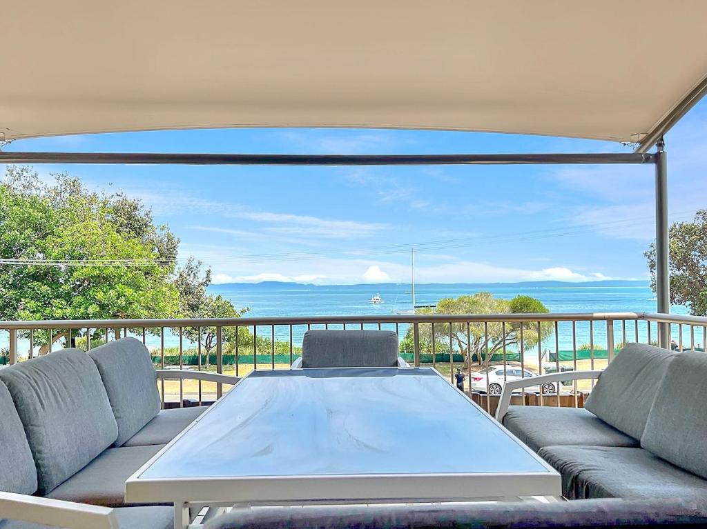 a table and chairs on a balcony with a view of the ocean at A Yachtsmans Rest Unit 3 37 Victoria Parade in Nelson Bay