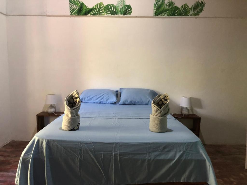 a bedroom with a bed with two pillows on it at CABINA EL MANU in Golfito