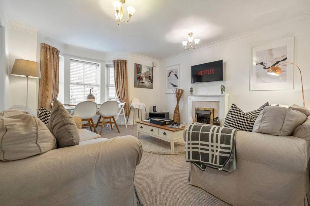 a living room with two couches and a fire place at Spacious Apartment with Parking! in Jesmond