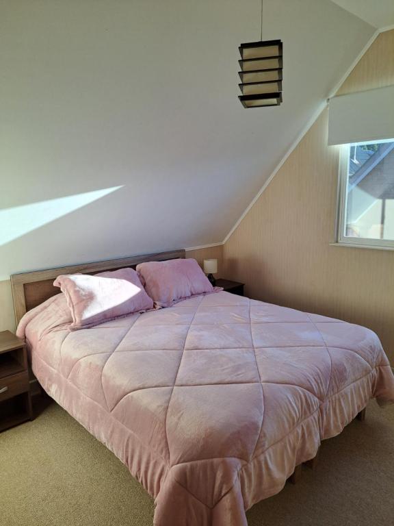a bedroom with a bed with purple sheets and a window at House Patagonia II in Coihaique