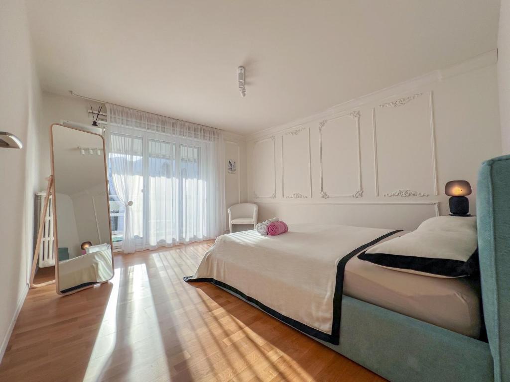 ein Schlafzimmer mit einem großen Bett und einem Spiegel in der Unterkunft Suite Room in shared apartment with Mt Rigi View in Goldau