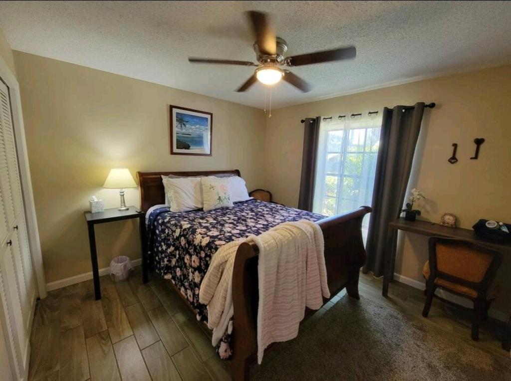 Schlafzimmer mit einem Bett und einem Deckenventilator in der Unterkunft Harmony Bed and Breakfast Private Queen GardenviewRoom in Lutz
