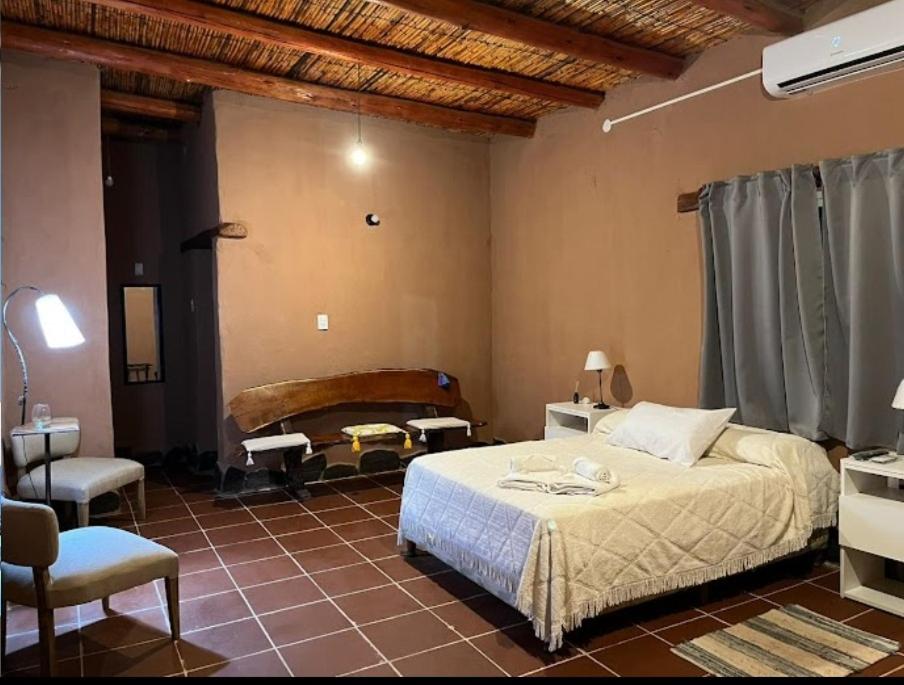 una camera con letto, tavolo e sedia di Hotel de campo luna a Tinogasta