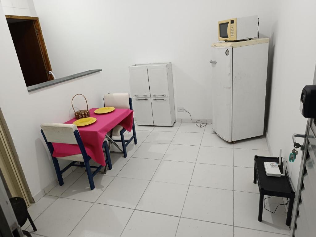 cocina con mesa roja y 2 neveras en Apartamento Quarto e Cozinha cod 4 Tremembe, en São Paulo