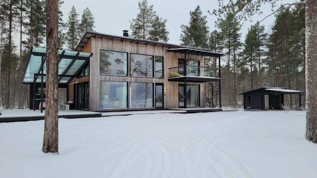 una casa en el bosque en la nieve en Villa Hekuma en Keränen