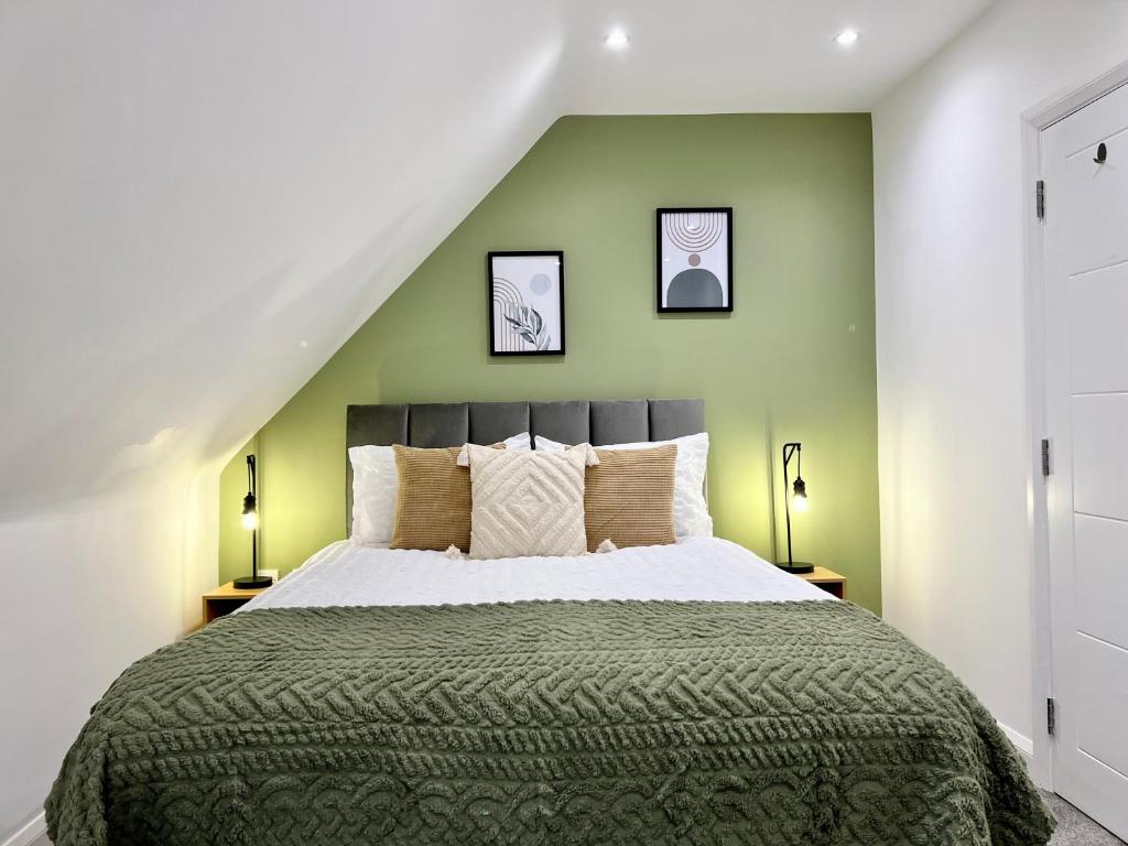 una camera da letto con un grande letto con pareti verdi di 2-bed flat in central Borehamwood location a Borehamwood