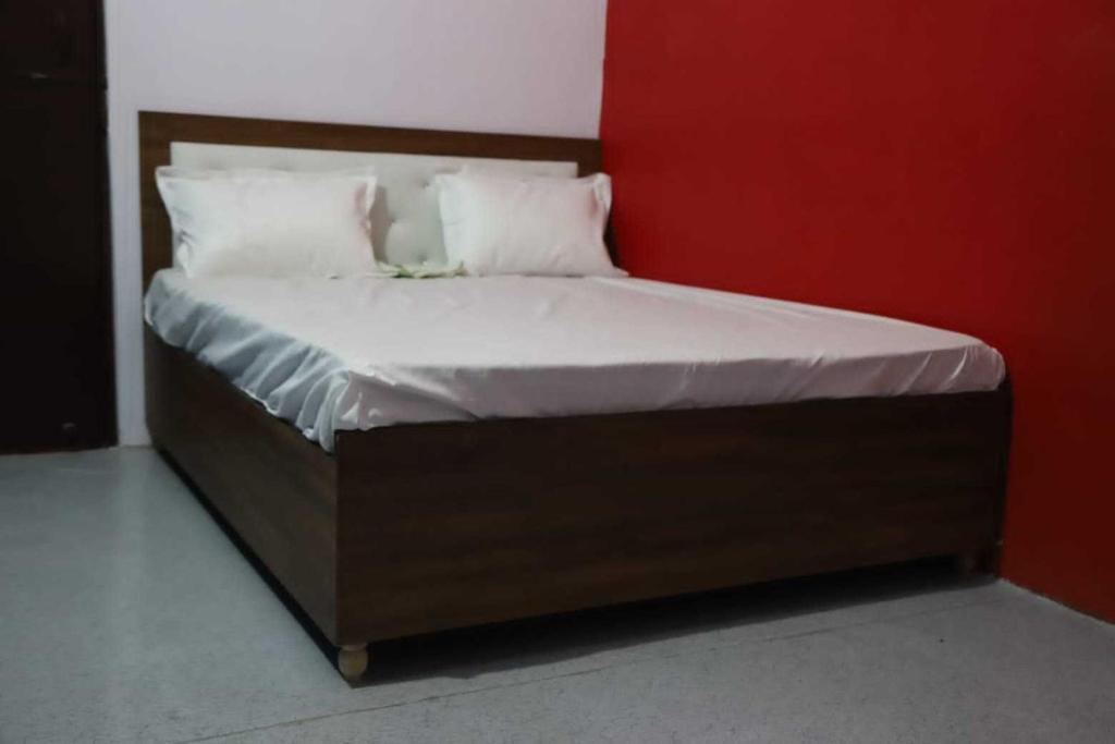 - un lit avec des draps et des oreillers blancs dans l'établissement OYO Hotel Grand AB, à Meerut
