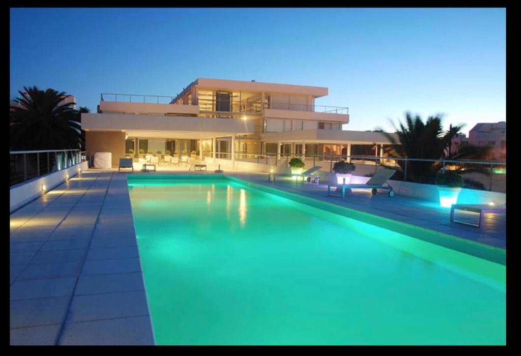una casa grande con piscina por la noche en Hermoso apto en Edificio Gala Puerto en Punta del Este