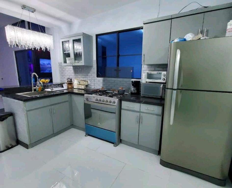 a kitchen with stainless steel appliances and a large window at Marhabibi's home in Sonsonate