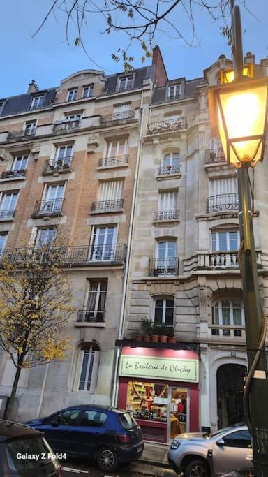 un grand bâtiment avec une voiture garée devant dans l'établissement Easy Paris, à Clichy