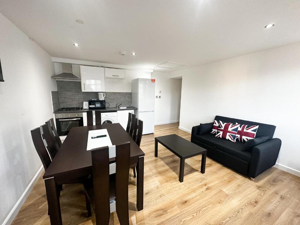 - une cuisine et une salle à manger avec une table et un canapé dans l'établissement Camden Apartment, à Londres