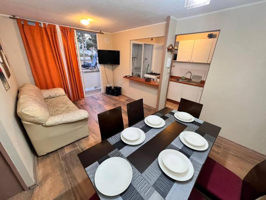 sala de estar con mesa, sillas y sofá en Hermoso y acogedor apartamento en el tabo, en El Tabo