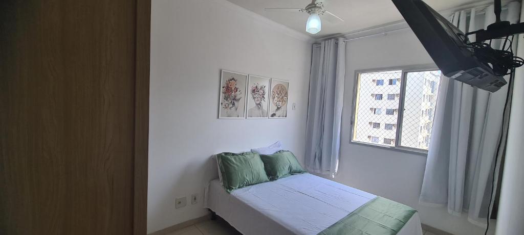 a bedroom with a bed with green pillows and a window at 603 SEVILHA in Serra