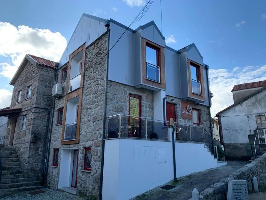 a stone house with a large white garage at Casa da Carvalha - Loriga in Loriga