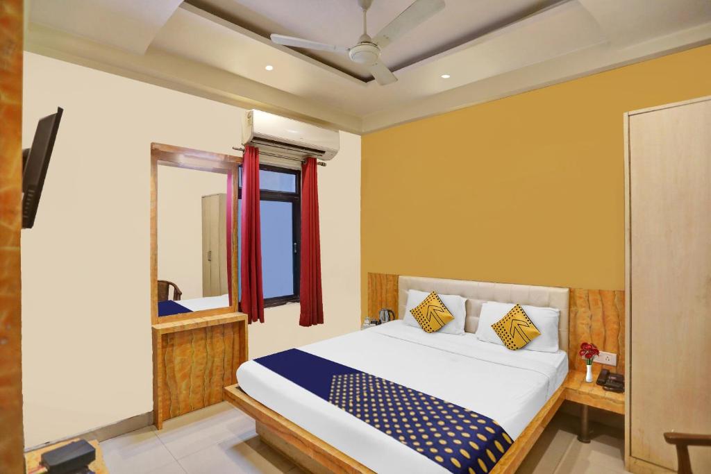 1 dormitorio con cama y espejo en SPOT ON Hotel Harmony en Muthiganj