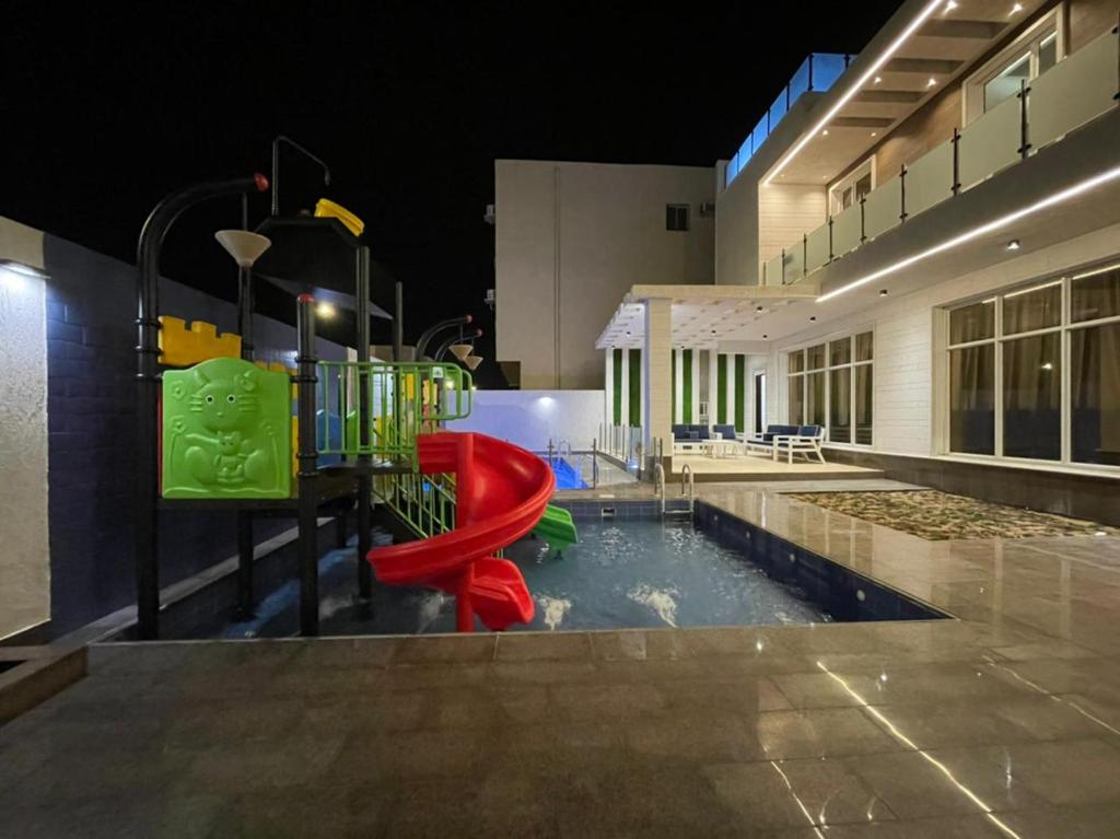 a swimming pool with a playground in a building at شاليه رحال in Yanbu Al Bahr