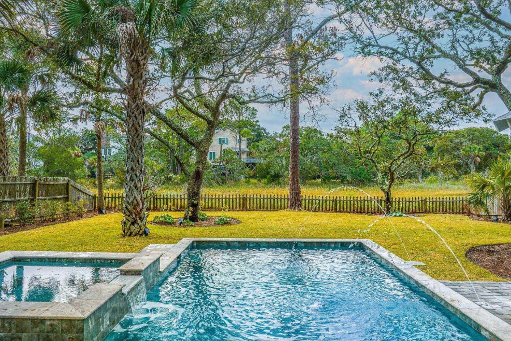 a swimming pool in a yard with trees at Heron Hideaway in Folly Beach