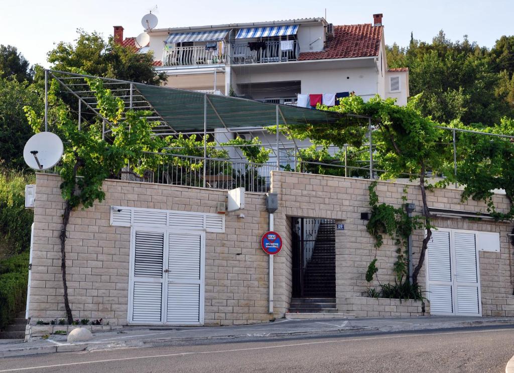 una casa de ladrillo con puertas blancas y un edificio en Apartment BM ST2, en Split
