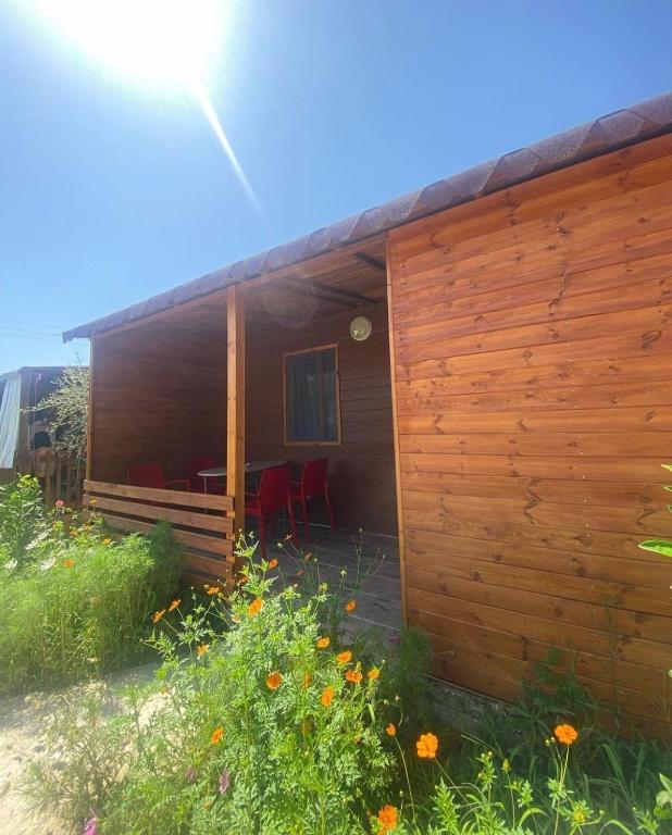 a wooden house with a fence and some flowers at Violet Village in Borsh