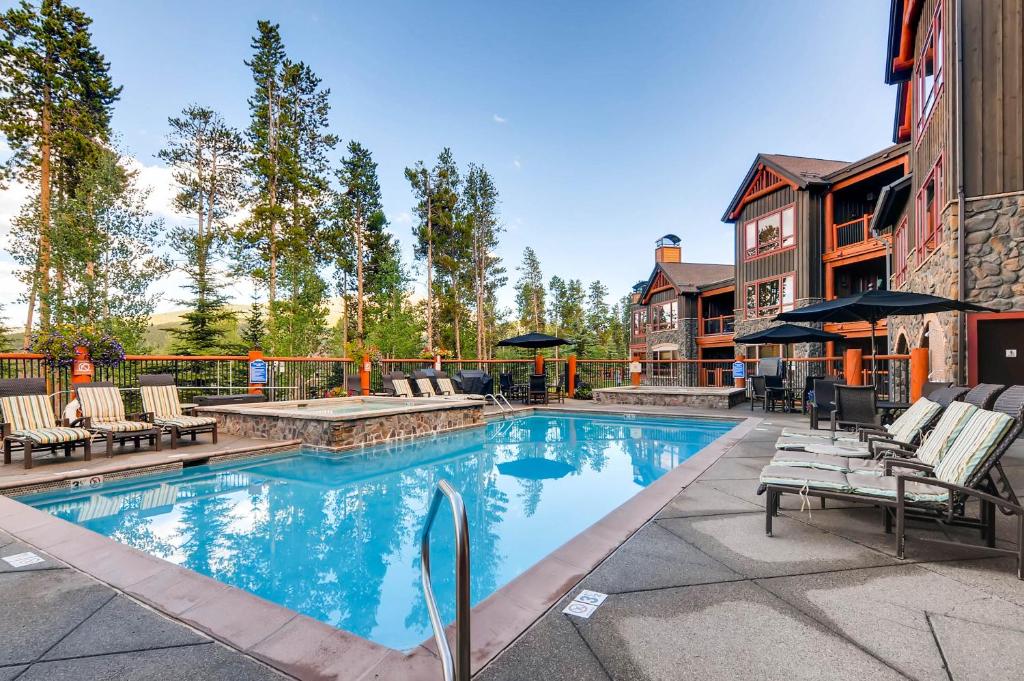 a swimming pool with lounge chairs and a house at BlueSky Breckenridge in Breckenridge