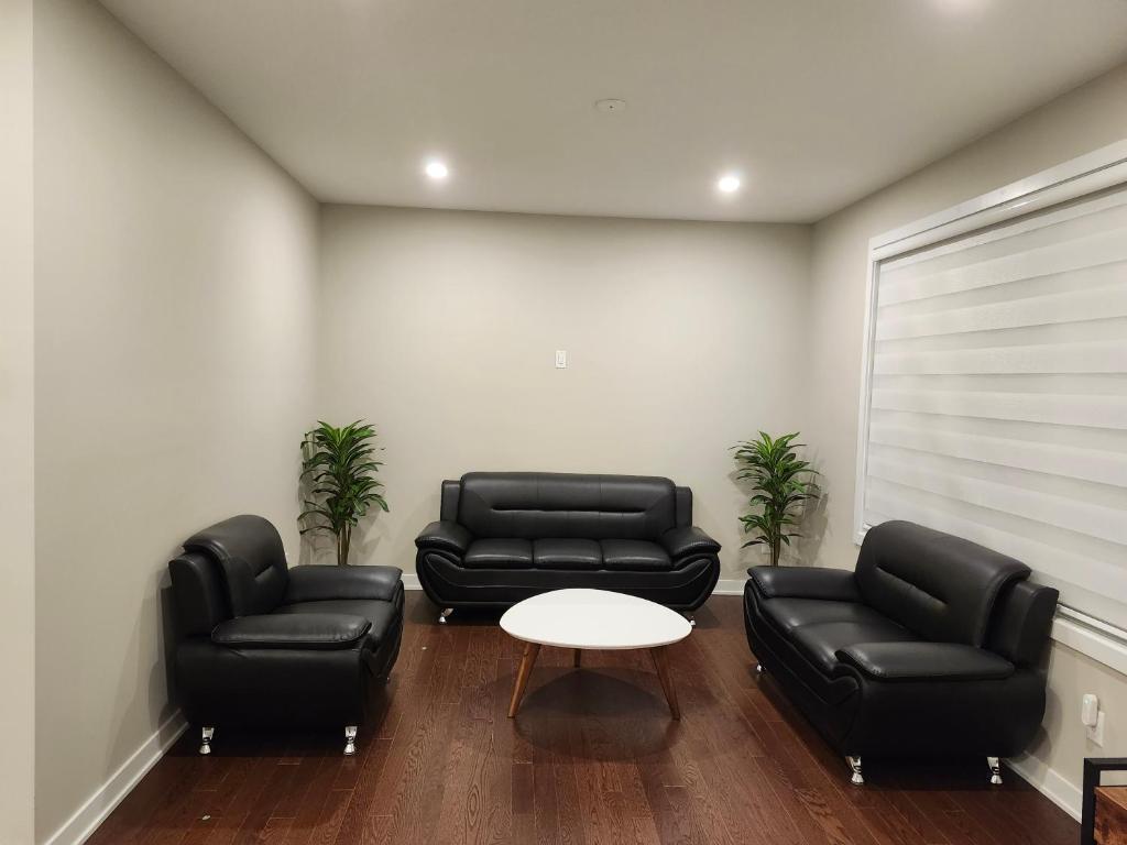 2 divani in pelle nera e un tavolo in una stanza di Brand New-Budget friendly master bedroom-House a Carleton Place