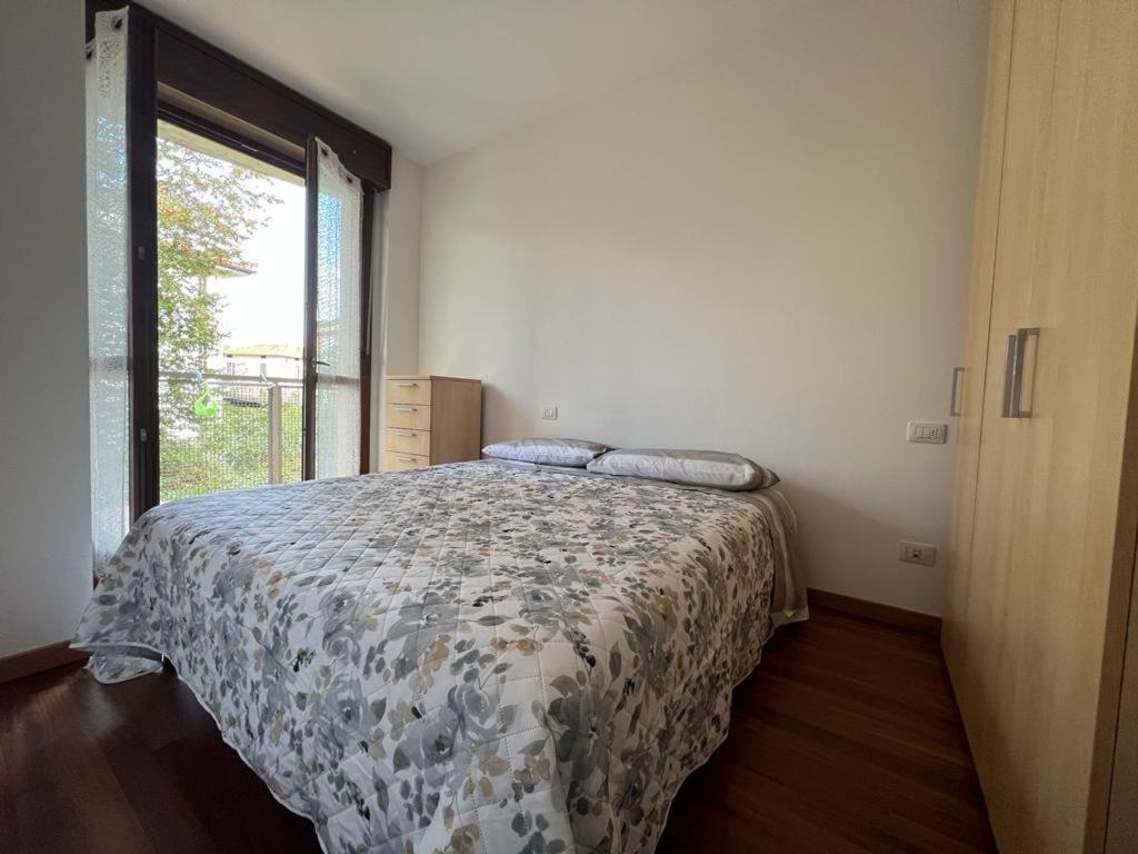 een slaapkamer met een bed met een dekbed en een raam bij Berghome in Bergamo