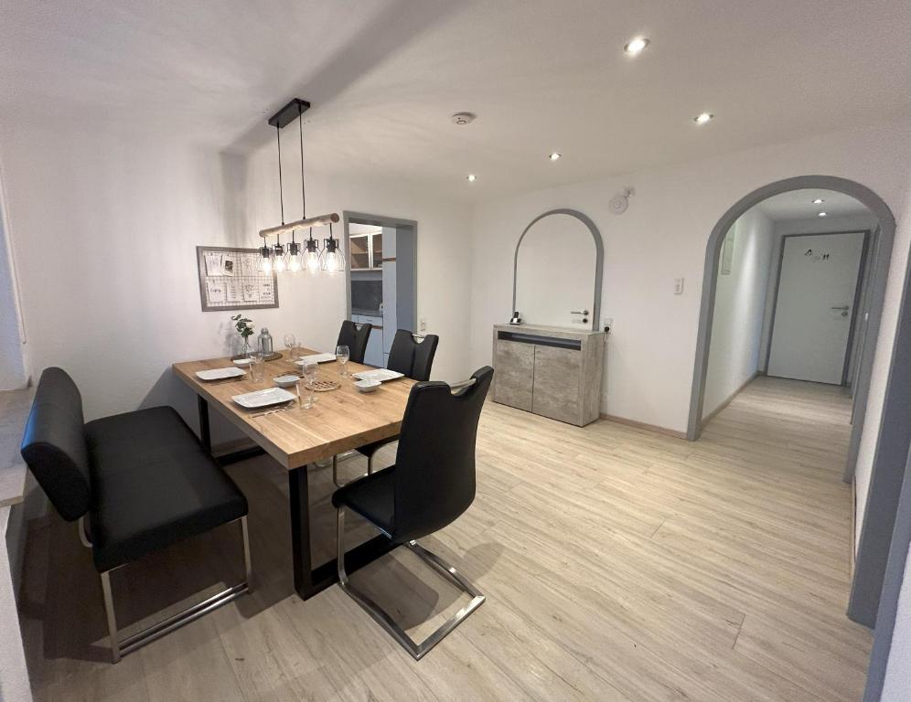 ein Esszimmer mit einem Holztisch und schwarzen Stühlen in der Unterkunft Ferienwohnung zur Birke in Neuhausen ob Eck