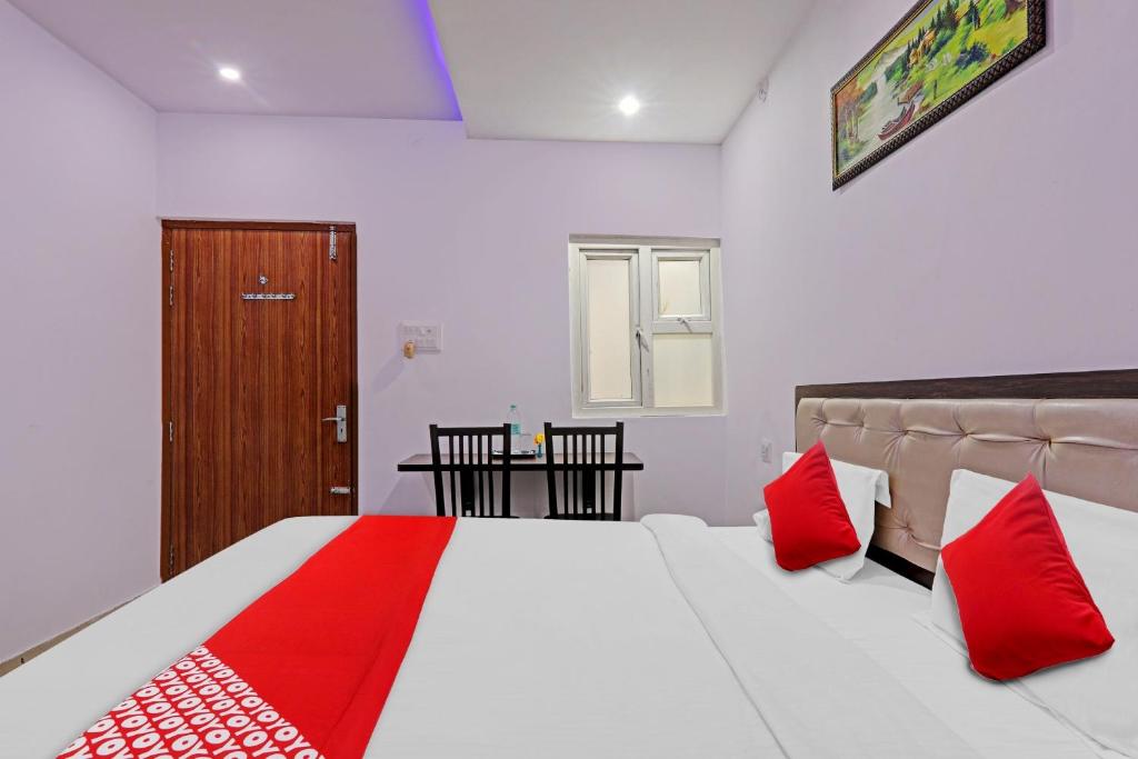 a bedroom with a large bed with red pillows at Collection O Hotel Prime A-One Inn Near Chaudhary Charan Singh International Airport in Bijnaur