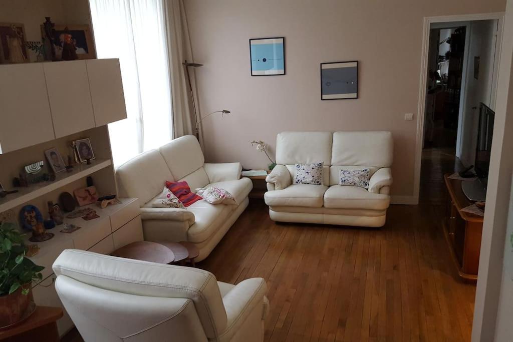 - un salon avec deux canapés blancs dans l'établissement Apaprtement entre Nation et Daumesnil 5 métros, 1 RER, 4 bus, à Paris