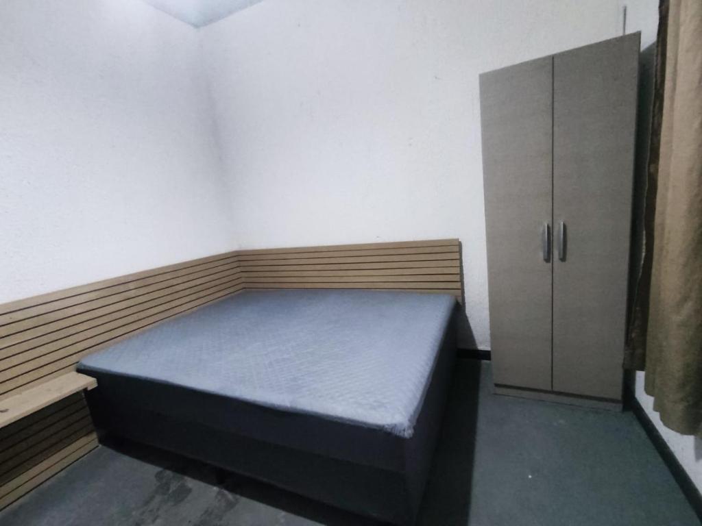 a small room with a bed and a cabinet at Casa aconchego com piscina in Guaratuba