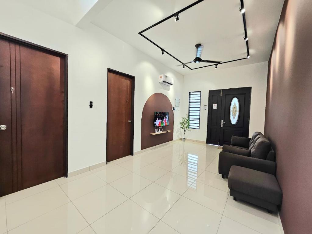 a living room with brown doors and a couch at Air-home No 28 Simpang near Aulong Econsave, 3BR, 7pax, Netflix in Simpang