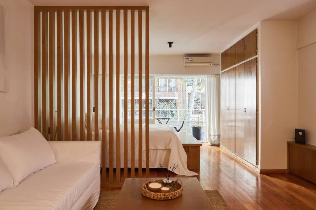 um quarto com uma cama e uma grande janela em Hestia At Palermo Charming Studio W Balcony em Buenos Aires